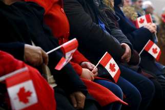  Syrian refugees hold Canadian flags as they take part in a welcome service in 2015 at a church in Toronto. The Catholic Church and Catholic agencies that work with migrants and refugees around the world are called to educate, advocate and seek alternative host countries in the face of a growing &quot;refusal to welcome&quot; newcomers, said a top Vatican official. 
