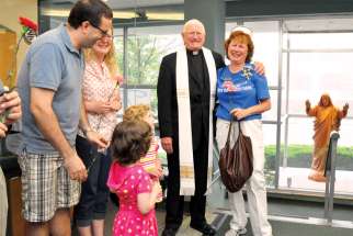 Fr. Michael Prieur shares some smiles with a family.