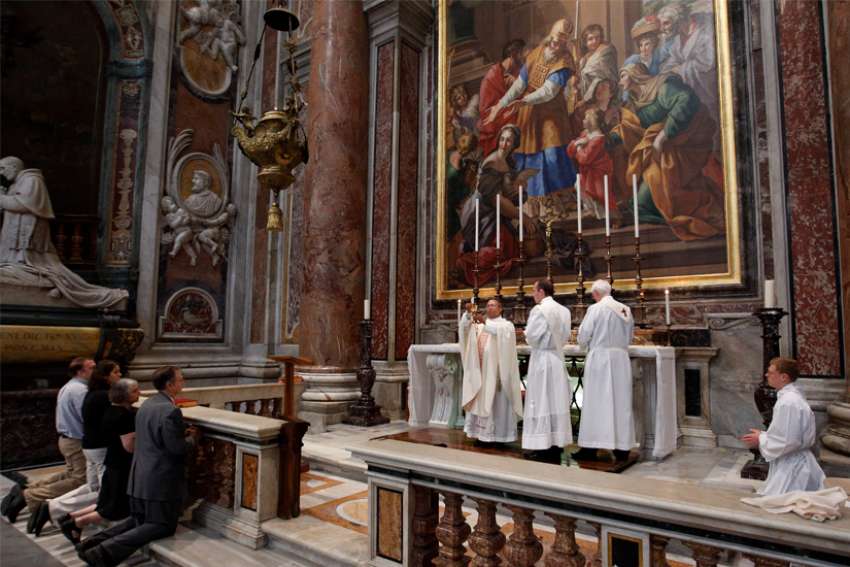 A priest holds the Eucharist as he celebrates a private Mass at a chapel in St. Peter&#039;s Basilica at the Vatican in this Oct. 8, 2011, file photo. The new archpriest of St. Peter&#039;s Basilica, Cardinal Mauro Gambetti, has reaffirmed the principles that led the Vatican to severely limit private celebrations of Mass in the basilica in the early morning, but said exceptions would be made for &quot;groups with particular and legitimate needs.&quot;