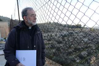 Bishop Lionel Gendron of Saint-Jean-Longueuil, Quebec, looks through a fence at the Cremisan Valley from the Salesian Sisters&#039; convent in Beit Jalla, West Bank 2015.