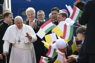 Pope Francis greets well-wishers as he arrives at the international airport in Budapest, Hungary, April 28, 2023. The pope was beginning a three-day trip to Hungary&#039;s capital.