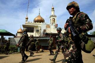 Philippine government soldiers walk past a mosque before their May 25 assault on Maute insurgents, who have taken over large parts of the town of Marawi. Catholic bishops in the region have expressed their support of the government’s declaration of martial law, as long as it’s temporary.