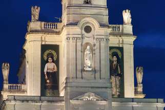 Banners showing Sts. Jacinta and Francisco Marto, two of the three Fatima seers, hang from the facade of the Basilica of Our Lady of the Rosary of Fatima as Pope Francis visits the Shrine of Our Lady of Fatima in Portugal, May 12. 