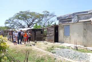 A group of people head toward an outdoor meeting space used by Catholics in the Cuban countryside in this early March photo. With few places to worship, some Catholics have been using makeshift chapels or mission houses, with little more than a tin roof over them, to pray, gather for Mass or teach the catechism in places where there is no parish.