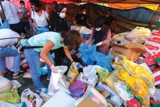 A volunteer gathers supplies in Beirut Aug. 5 to be distributed to people affected by the previous day’s explosions.
