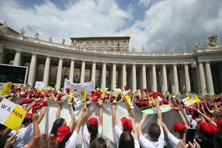  Young people wave as Pope Francis leads the &quot;Regina Coeli&quot; from the window of his studio overlooking St. Peter&#039;s Square May 13 at the Vatican. 