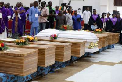 Flowers lie on caskets during a funeral Mass for some of the 40 victims killed in a 2022 attack by gunmen during Mass in Nigeria. Nigeria figures prominently in Pew Research’s latest report on religious persecution around the world.