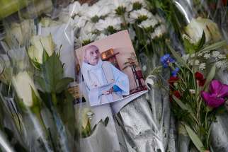 A photo of slain Father Jacques Hamel is seen among flowers at a makeshift memorial in Saint-Etienne-du-Rouvray, near Rouen, France, July 27, 2016.