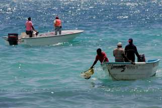 In this March 3, 2008 photo, environmental workers collect sea samples after an oil spill at Boca Chica, Dominican Republic. 