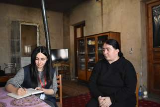 A Caritas Armenia social worker helps a refugee from Nagorno Karabakh, what Armenians call Artsakh, an ancient Armenian homeland.