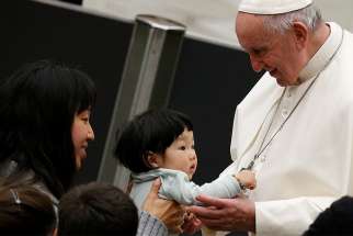Pope Francis greets a child during his general audience in Paul VI hall at the Vatican Jan. 9. 