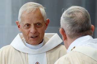 Cardinal Donald W. Wuerl of Washington prepares to exchange the sign of peace with Pope Francis as the Pope celebrates Mass in Washington Sept. 23, 2015.