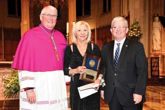 Teresa Susi is presented with her Award for Distinguished Service by Hamilton Bishop Douglas Crosby and Patrick Daly, chair of the Hamilton-Wentworth Catholic District School Board.