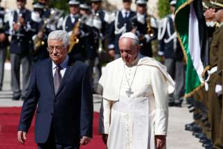 Pope Francis reviews the honour guard with Palestinian President Mahmoud Abbas during an arrival ceremony at the presidential palace in Bethlehem, West Bank, May 25, 2014.