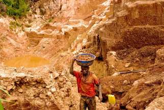 A Congolese mine worker carries gold rich earth out of a pit for water processing in 2009 in Chudja. Church leaders say telling companies they no longer have to disclose whether their firms use &quot;conflict minerals&quot; would be a bad move.