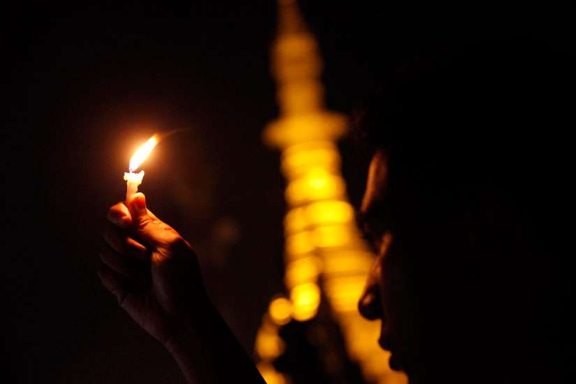 A person holds a candle during a prayer service in Yangon, Myanmar, Dec. 23, 2014. 