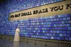 Pope Francis pauses in front of a display at the National 9/11 Memorial and Museum in New York Sept. 25. The Virgil quotation on the wall reads, &quot;No day shall erase you from the memory of time.&quot; 