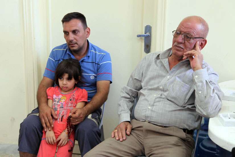 A Christian family who fled from violence in Mosul, Iraq, sit in the room of a church in 2014 in Amman, Jordan. The Vatican is funding a job-creation program for Iraqi refugees in Jordan, a country that is hosting close to 1.5 million refugees, but is struggling to provide work for them.