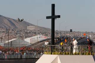 Pope Francis prays at a cross on the border with El Paso, Texas, before celebrating Mass at the fairgrounds in Ciudad Juarez, Mexico, Feb. 17. 