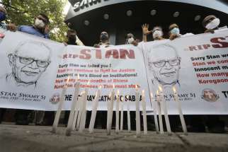 People hold a banner during a prayer service for Jesuit Fr. Stan Swamy in Mumbai, India, July 6 after he died at a hospital the previous day.