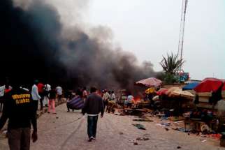 Smoke rises after a bomb blast at the market district in Jos, Nigeria, May 20. Back-to-back bombings killed at least 118 people and wounded 45 in the crowded business district of the central Nigerian city, the National Emergency Management Agency reporte d, in an attack that appeared to bear the hallmarks of Boko Haram insurgents.