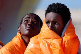 Migrants stand in line after disembarking from the Norwegian vessel Siem Pilot at Sicilian harbor of Pozzallo March 29, 2016. 
