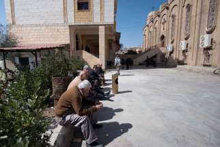 Displaced Assyrians, who fled from the villages around Tel Tamr, Syria, gather March 9 outside the Assyrian Church in Hassakeh as they wait for news about abductees remaining in Islamic State hands.