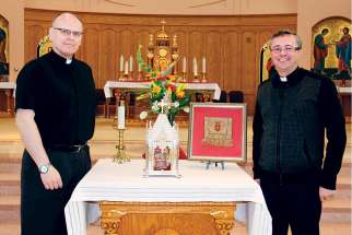 Fr. Joseph Pidskalny, OSBM, left, and Fr. Gabriel Haber, OSBM, stand beside St. Josaphat’s relics during the 400th anniversary celebration of the saint’s order at St. Mary’s Ukrainian Church in Vancouver March 25.