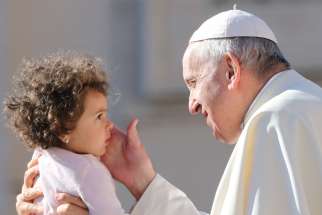 Pope Francis blesses a baby as he arrives to lead the Sept. 26 general audience in St. Peter&#039;s Square at the Vatican. 