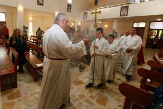 A clergyman and altar servers process during Mass July 20, 2014, at St. Joseph Chaldean Catholic Church in Baghdad, Iraq. Chaldean Christians in northern Iraq are determined to continue their 2,000-year-long mission despite the near-deadly blow inflicted by Islamic State forces and new challenges from nongovernment militias, said a priest ministering in the region.