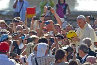 Pope Francis holds a sports ball that was given to him as he arrives for his weekly audience in St. Peter&#039;s Square at the Vatican Aug. 26, 2015.