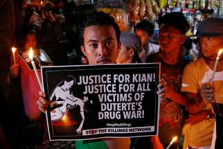 A young man in Manila, Philippines, holds a placard Aug. 25 at a memorial for Kian Delos Santos, a 17-year-old shot in an escalation of Philippine President Rodrigo Duterte&#039;s war on drugs.