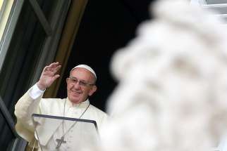 Pope Francis waves to the crowd as he leads the Angelus from the window of his studio overlooking St. Peter&#039;s Square Oct. 29 at the Vatican. 