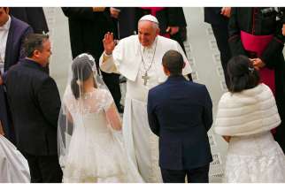 Pope Francis gestures to newlywed couples during his weekly audience in Paul VI hall at the Vatican Jan. 21.