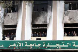 In this Dec. 29, 2013, file photo, Egyptian students look out the windows of a faculty building at Cairo&#039;s al-Azhar University one day after student supporters of the Muslim Brotherhood set it on fire in Cairo, Egypt. The Vatican&#039;s interreligious council invited Ahmad el-Tayeb, the grand imam of al-Azhar University, to travel to the Vatican and meet with Pope Francis.