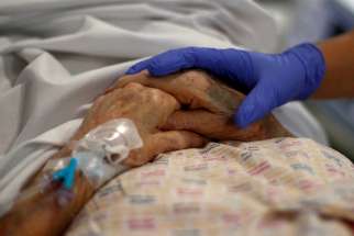 A health care worker comforts an eldery patient at a hospital in Blackburn, England, May 14, 2020, during the COVID-19 pandemic. In his message for the Feb. 11 celebration of the World Day of the Sick, Pope Francis called on Christians to practice what they preach, including by guaranteeing equal access to health care for all people.