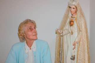 Natalie Martha Loya, pictured in an undated photo, gazes at a statue of Our Lady of Fatima that crisscrossed the country with her during her 35-year apostolate of spreading the Fatima message.