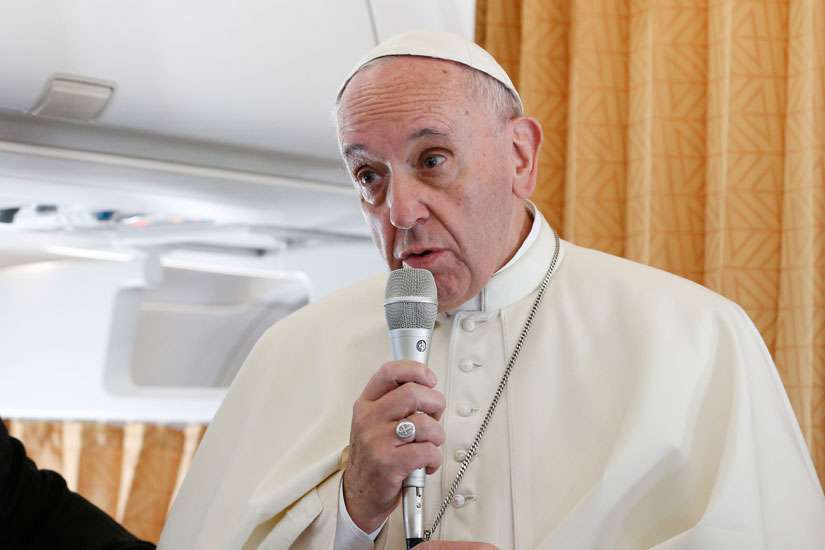 Pope Francis stands next to Jesuit Father Federico Lombardi, Vatican spokesman, as he speaks to journalists aboard his flight from Rome to Krakow, Poland, July 27. The Pope sends a video message specifically to those who couldn&#039;t afford to attend World Youth Day back in Havana, Cuba, July 29.