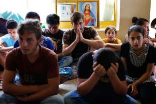 Displaced Iraqi Christians who fled from Islamic State militants in Mosul pray at a school acting as a refugee camp in Irbil, Iraq, Sept. 6. Irbil now hosts more than 100,000 displaced Christians and other minorities. Some Christians who have fled Iraq say they do not want to return