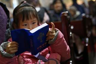A girl reads a Bible during Mass in the state-approved Xuanwumen Catholic Church in Bejing, China, Dec. 4, 2016. While the Chinese government technically recognizes Catholicism as one of five religions in the country, it does not recognize many Church leaders appointed by the Vatican, driving many among the Catholic Church leadership and laity underground.