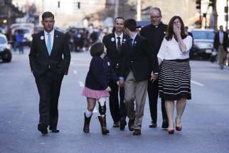 The family of Boston Marathon bombing victim Martin Richard walk along Boylston Street April 15 with a clergyman and Boston Mayor Marty Walsh, left, following a ceremony at the site of the second bomb blast on the second anniversary of the bombings. Mart in&#039;s father, Bill, smiles as he walks behind his daughter, Jane, second from left, son Henry and wife Denise, right. Young Martin was killed in the attack, just a few days shy of his ninth birthday.