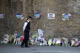  A police officer stands in front of messages and tributes June 19 left near where a man died and 10 people were injured after a van was rammed into a crowd of worshippers near a mosque in north London. A 48-year-old man was arrested in the collision with pedestrians outside the Muslim Welfare House, police said.