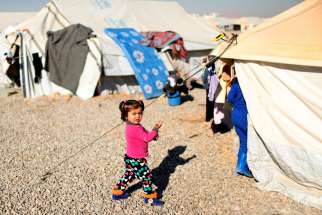 A displaced Iraqi child walks outside tents Dec. 9 at the Hassan Sham camp near Mosul.