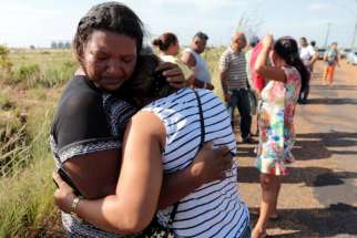 Relatives of prisoners reacts as they wait for news at a checkpoint close to the a prison where at least 33 people were killed during a Jan. 6 riot in Roraima, Brazil.