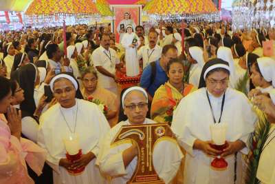 Sister Anne Joseph, superior general of the Franciscan Clarist order, carries the relic of Blessed Rani Maria Vattali during her Nov. 4 beatification Mass in Indore, India. At right is Sister Selmy Paul, younger sibling of Blessed Rani Maria, who was killed in 1995.