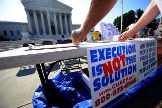 A member of the Abolition Action Committee hangs a sign in front of the Supreme Court in Washington during a 2008 vigil to abolish the death penalty.