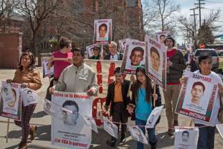 Demonstrators rally outside St. Anne&#039;s Catholic Church in Detroit to protest the September 2014 disappearance of 43 students from a teachers college in the southern Mexican state of Guerrero. The students from Ayotzinapa Teacher Training College were app arently arrested by local police who handed them over to a drug gang.