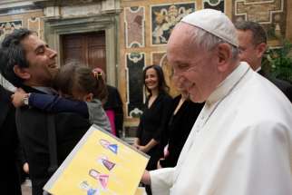 Pope Francis accepts a gift of artwork during an audience with members of the Foreign Press Association of Italy, at the Vatican May 18, 2019. 
