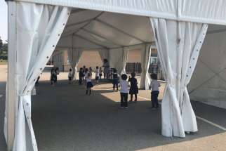 Father Serra School students take part in gym class under a tent in the school yard.