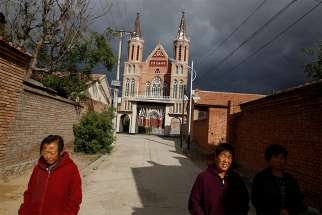 Villagers walk near a Catholic church in the village of Huangtugang, Hebei province, China, Sept. 30, 2018. In a new book, the Vatican secretary of state, Cardinal Pietro Parolin, writes that the Vatican&#039;s recent agreement with the Chinese government was motivated by a desire to spread the Gospel and assure freedom of the church.